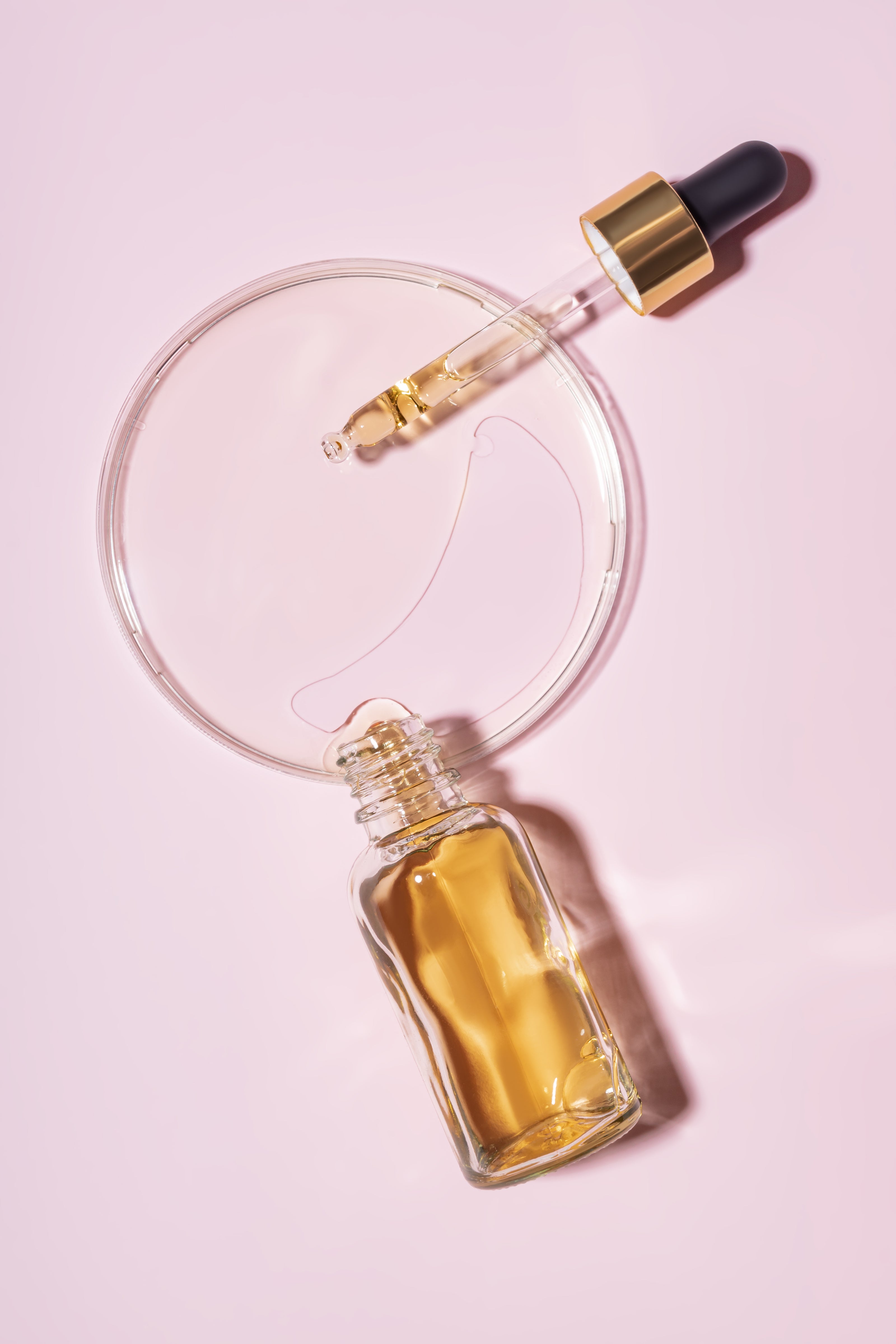 dropper bottle and petri dish with drops of pheromone fragrance
