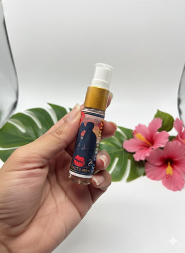 Hand holding a small spray bottle with a colorful label against a neutral background